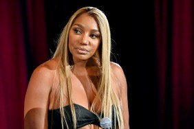 NeNe Leakes looking to the side, sitting in front of a red curtain