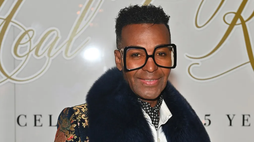 RHOA star Dwight Eubanks in large black glasses and a fur collar