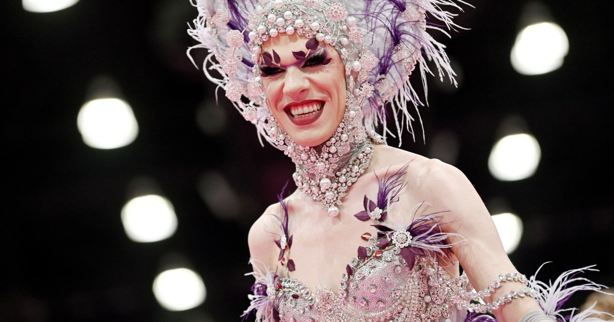 Utica Queen in a purple and silver head dress at Drag Con 2024