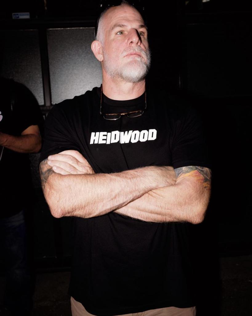 John "Shrek" McPhee standing with his arms crossed.