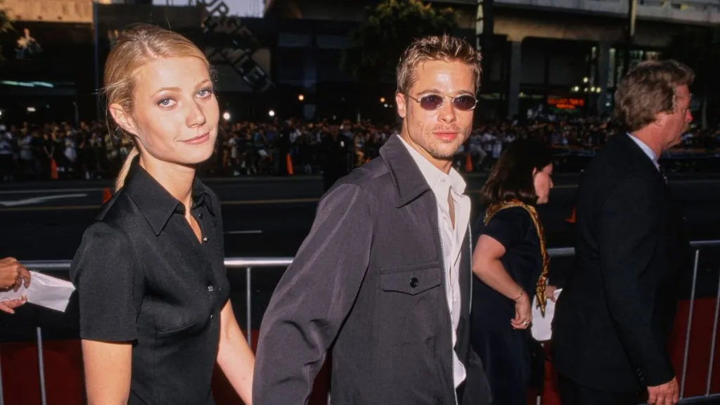 American actress Gwyneth Paltrow, wearing a black short-sleeved outfit, and her partner, American actor Brad Pitt, who wears a dark grey jacket over a white shirt with sunglasses, attend the Hollywood premiere of 'Waterworld', at Mann's Chinese Theatre in the Hollywood neighbourhood of Los Angeles, California, 27th April 1995
