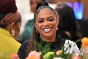 Kandi Burruss in a black shirt and smiling on an episode of RHOA