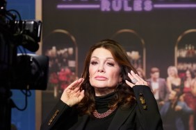 Lisa Vanderpump posing in front of a camera and a Vanderpump Rules poster