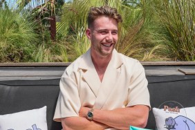 Harry Jowsey in a white shirt sitting with his arms crossed