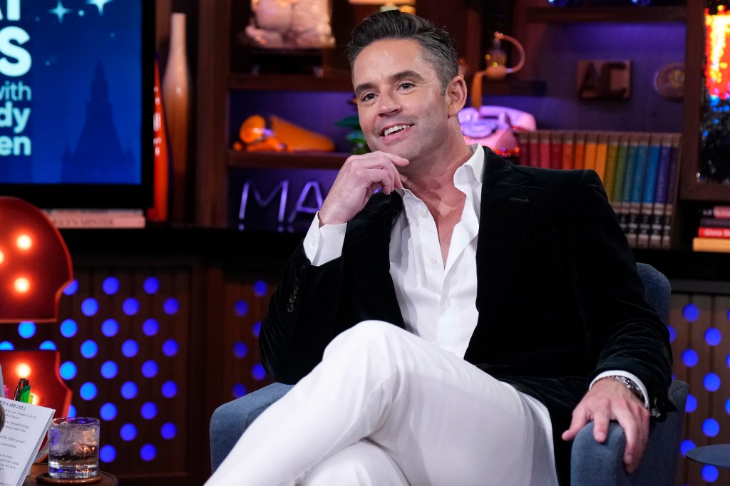 Jesse Lally sitting with his legs crossed on Watch What Happens Live