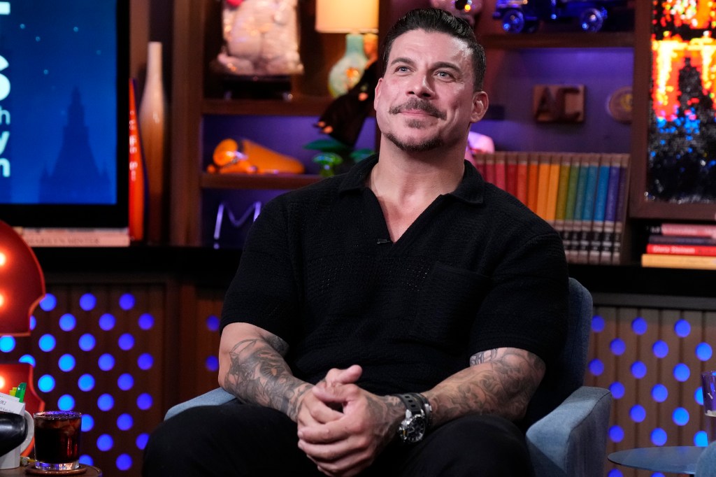 Jax Taylor wearing black, sitting with his hands folded on Watch What Happens Live