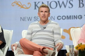 Todd Chrisley in pink pants and a grey striped sweater sitting with his legs crossed