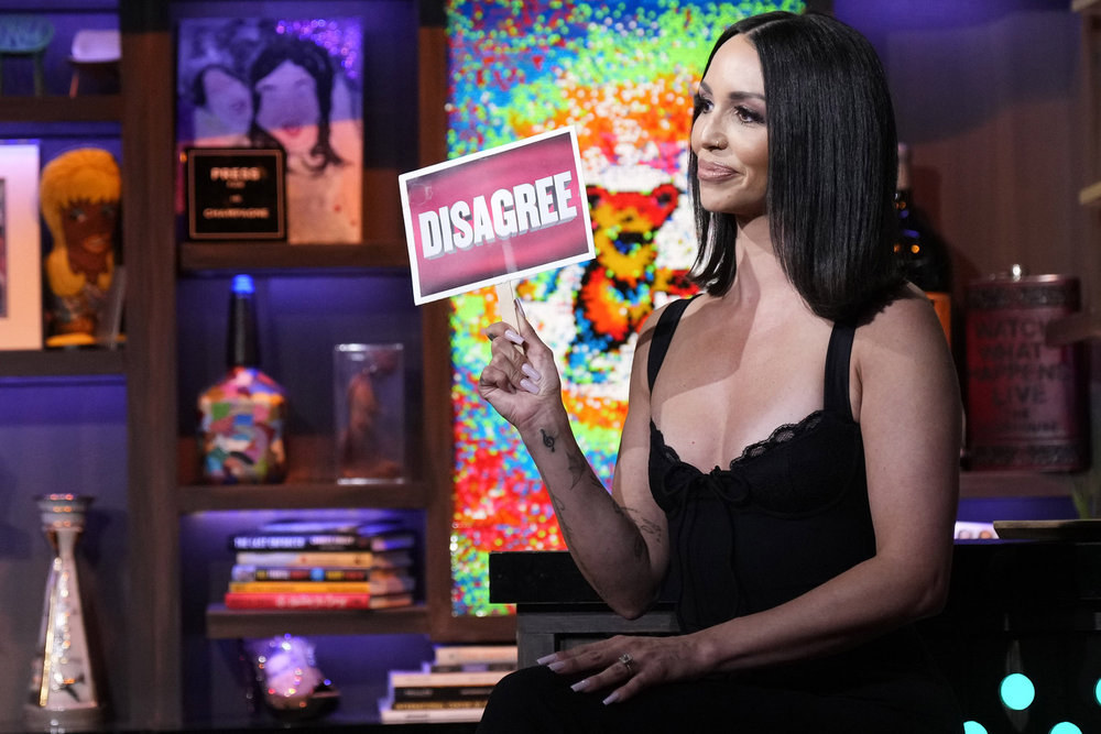 Scheana Shay on Watch What Happens Live holding up a sign that says, "Disagree." 