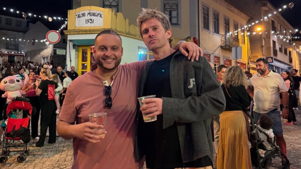 Omar Zaki and Charlie Zakkour posing together on a busy street