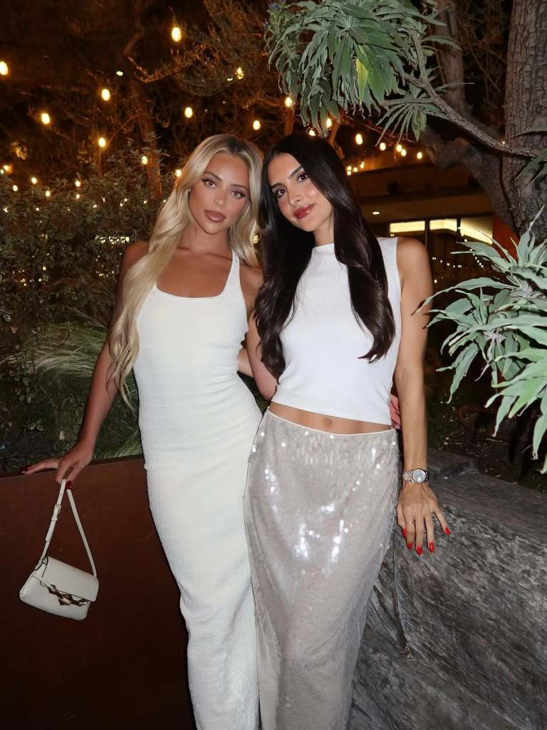 Sophia Umansky and Liv Walker posing together wearing white dresses