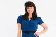 Kenley Collins in a blue dress standing with her hand on her hip for Project Runway Season 5