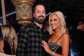 Travis Mullen and Gina Kirschenheiter backstage at BravoCon 2022, Gina is posing with her hand on Travis's chest