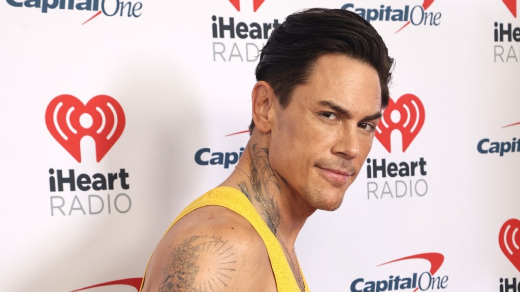 Tom Sandoval in a yellow tank top at an iHeartRadio event