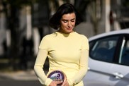 Bronwyn Newport in a yellow dress walking with her head down