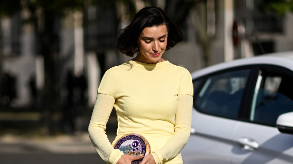 Bronwyn Newport in a yellow dress walking with her head down