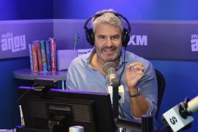 Andy Cohen with headphones in a blue shirt while recording a radio show