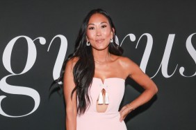 Katie Ginella in a pink dress posing with her hands on her hips