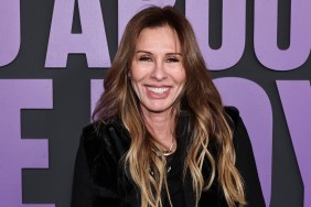 Carole Radzwill in a black coat standing in front of a purple sign