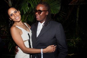 Racquel Chevremont in a white dress holding onto Mickalene Thomas, who is wearing a grey suit