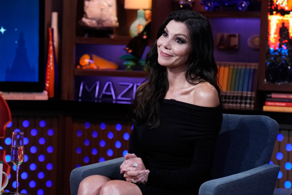 Heather Dubrow in a black dress on Watch What Happens Live, tilting her head and giving a side eye