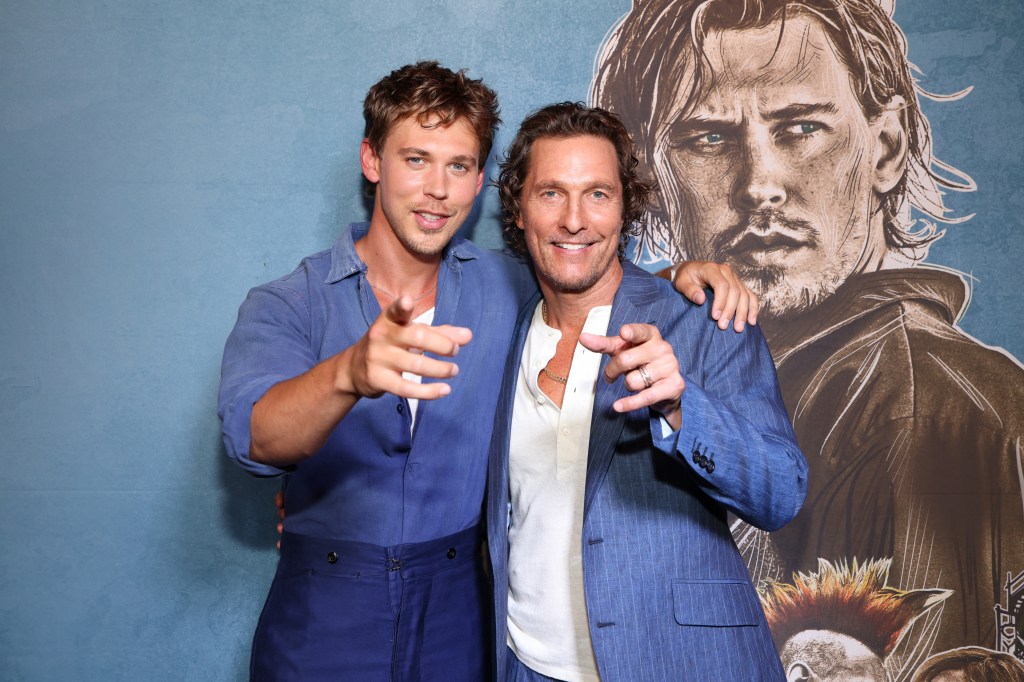 Austin Butler and Matthew McConaughey wearing matching blue and white suits and pointing at the camera