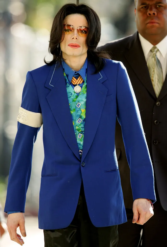 Michael Jackson in 2006 wearing a blue suit and orange sunglasses