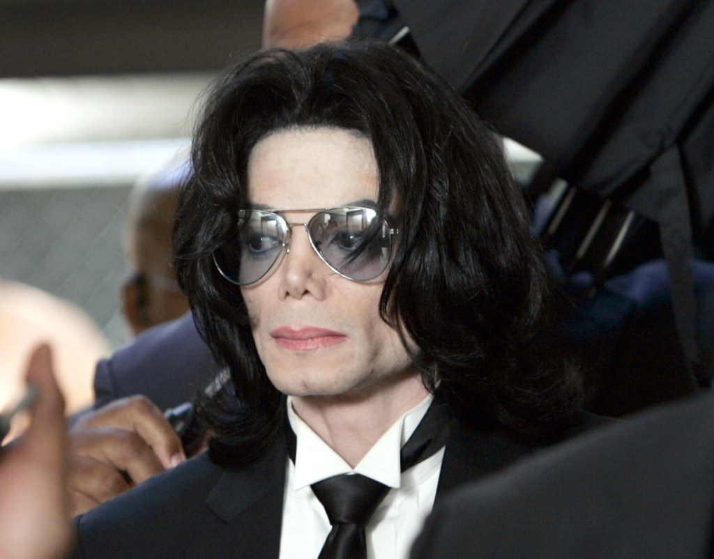 Michael Jackson in 2005 leaving a court room wearing a black suit and sunglasses