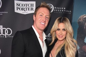 Kroy Biermann in a black suit posing with Kim Zolciak, who is wearing a black dress