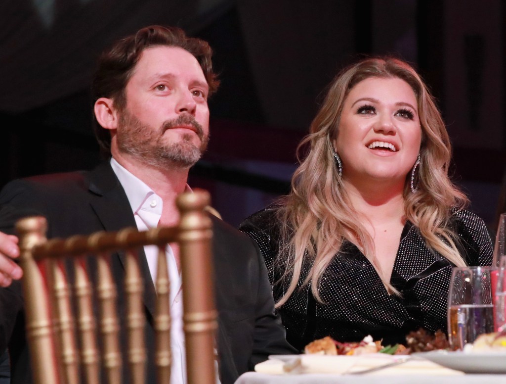 Brandon Blackstock and Kelly Clarkson sitting at a table together at a Billboard event