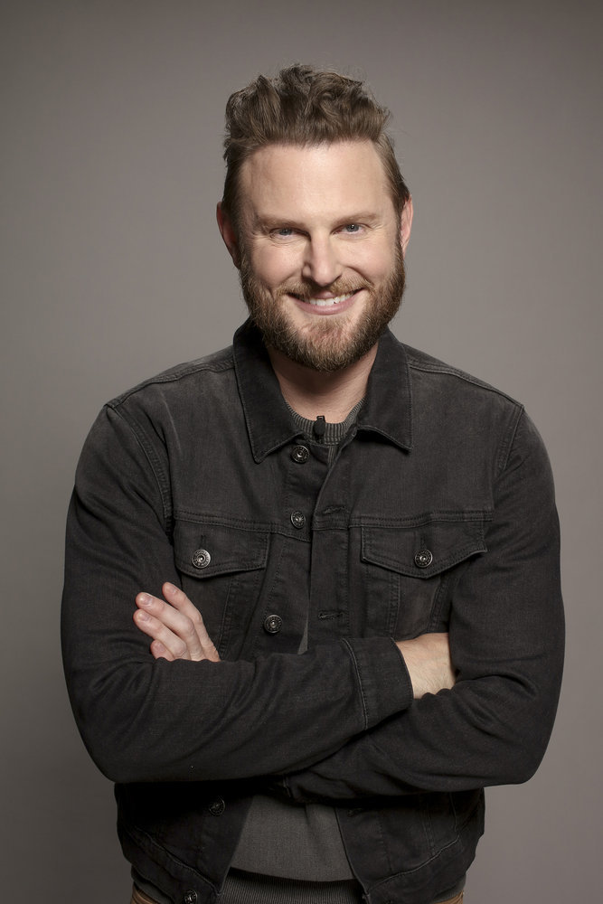 Bobby Berk in a grey denim jacket crossing his arms