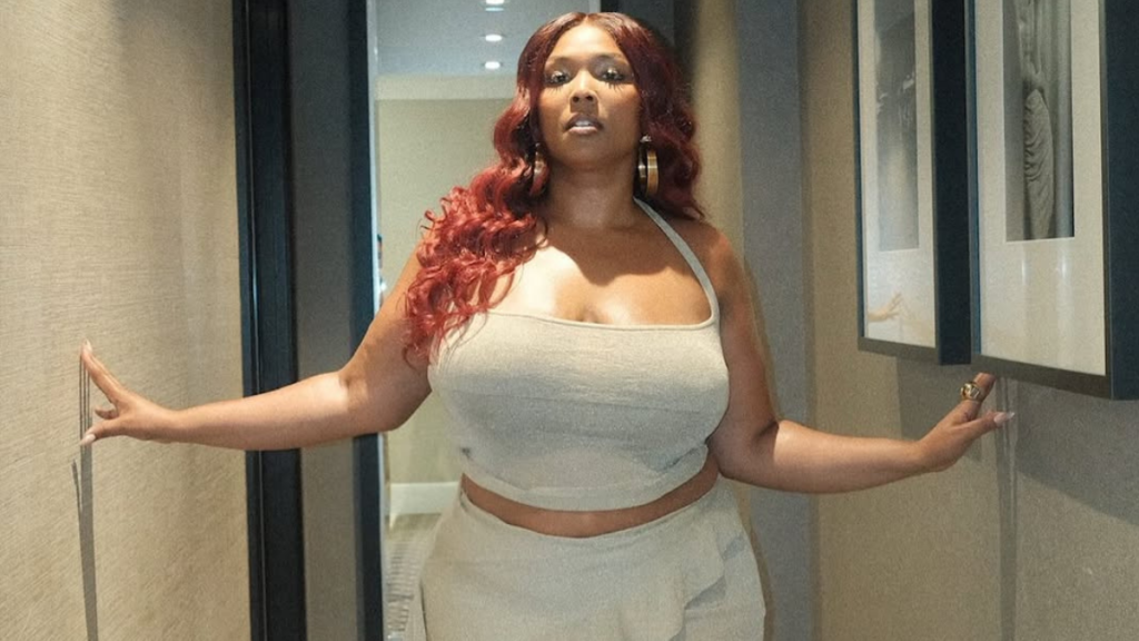 Lizzo wearing gold revealing two-piece set in heels photos