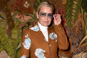 Yolanda Hadid posing in sunglasses and a brown coat