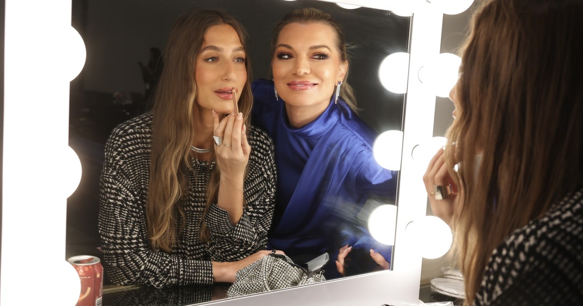 Amanda Batula and Lindsay Hubbard looking in a mirror whole Amanda touches up her makeup