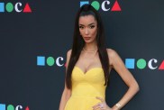 Noella Bergener posing in a yellow dress with her hand on her hip