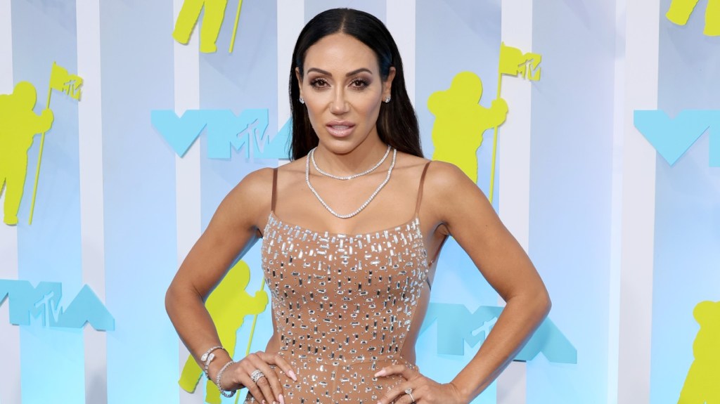 Melissa Gorga with her hands on her hips in a nude jumpsuit at the MTV VMAs