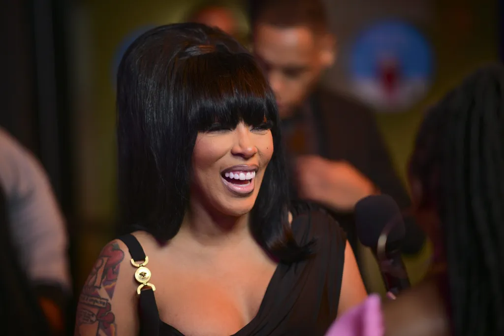 K. Michelle in a black dress with a large black bouffant hairstyle