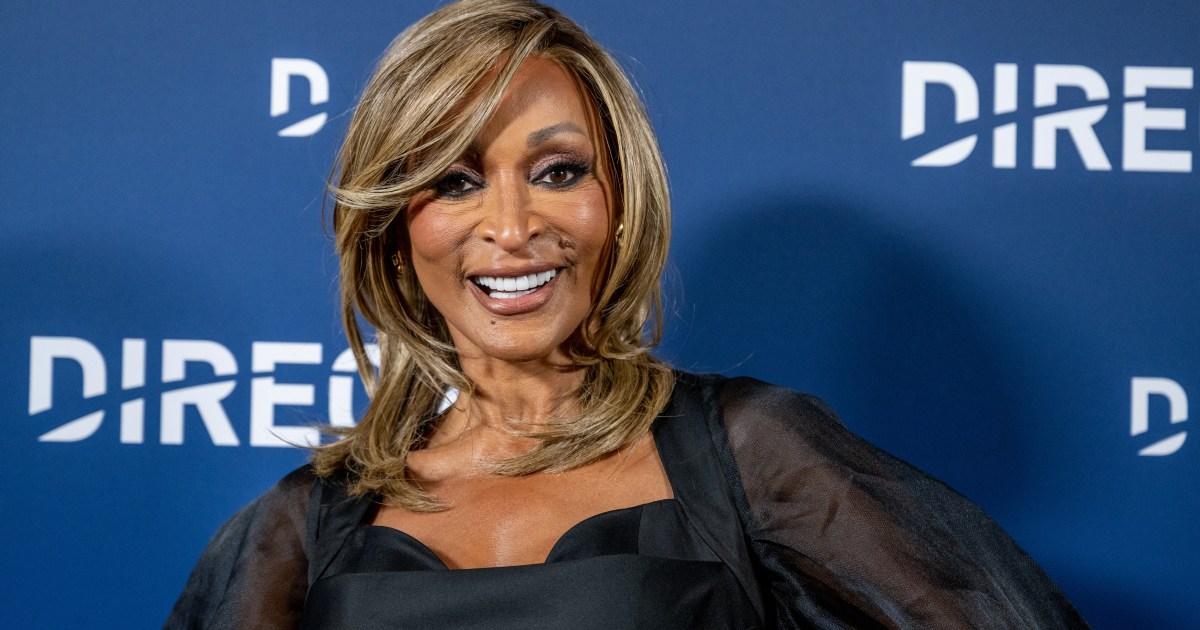 Karen Huger in a black dress posing and grinning at a Directv party