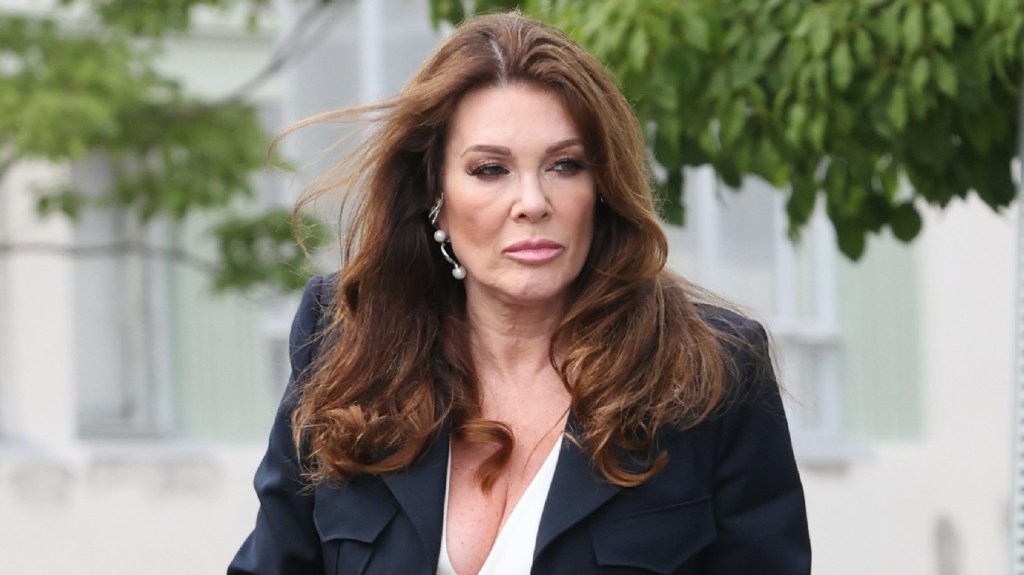 Lisa Vanderpump exiting a vehicle wearing a blue blazer and white top