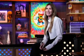 Carole Radziwill in a white jacket sitting next to the bar on Watch What Happens Live