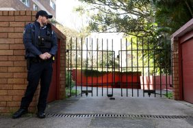 A police officer standing outside of a gate