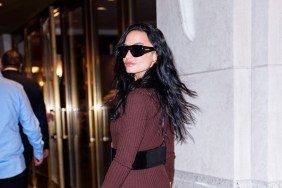 Demi Lovato in a red jumpsuit doing an over the shoulder pose outside of Watch What Happens Live