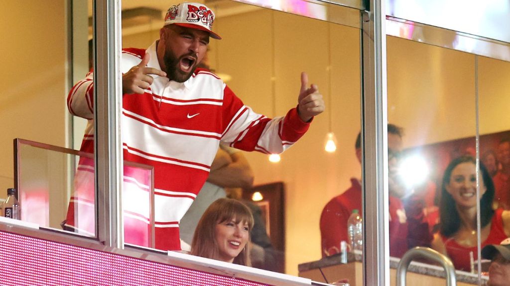 Travis Kelce #87 of the Kansas City Chiefs reacts as fiancee Taylor Swift smiles while watching from a suite during the second half of the game between the Cincinnati Bearcats and the Nebraska Cornhuskers at Arrowhead Stadium on August 28, 2025 in Kansas City, Missouri.