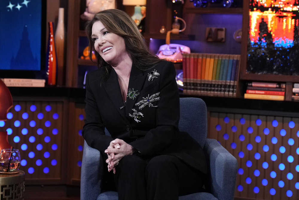 Lisa Vanderpump in a black blazer leaning over her chair on Watch What Happens Live 