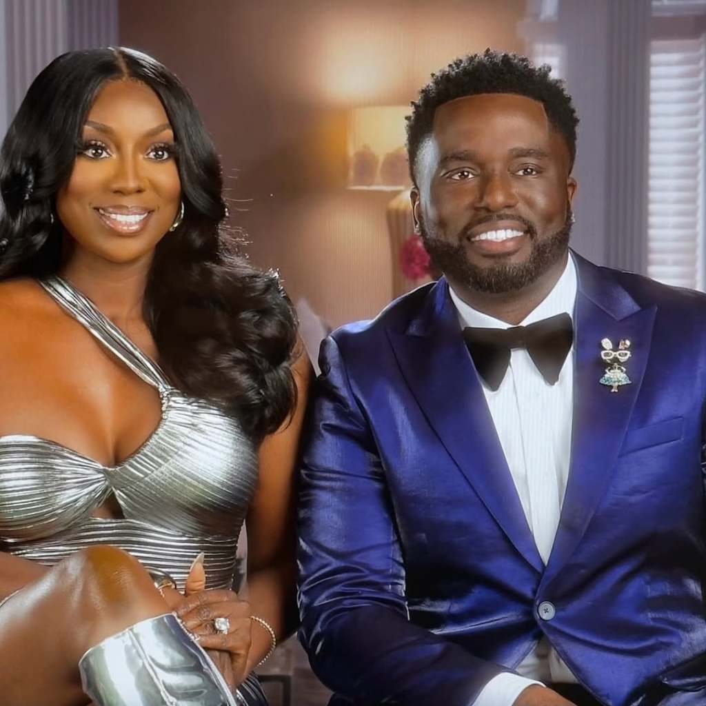 Wendy Osefo in a silver dress sitting with Eddie Osefo, wearing a blue suit, in a confessional on Real Housewives of Potomac