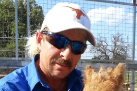 Joe Exotic in a white Longhorns hat, posing with an animal
