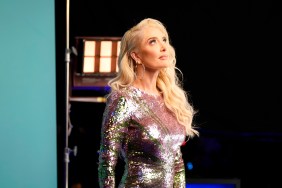 Erika Jayne in a silver dress, looking up at a stage light