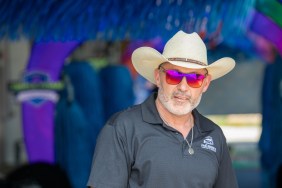 Steve McBee in a blue polo shirt and cowboy hat, standing inside of a car wash