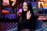 Lisa Barlow in a black sweater holding her hand up showing off her rings on Watch What Happens Live