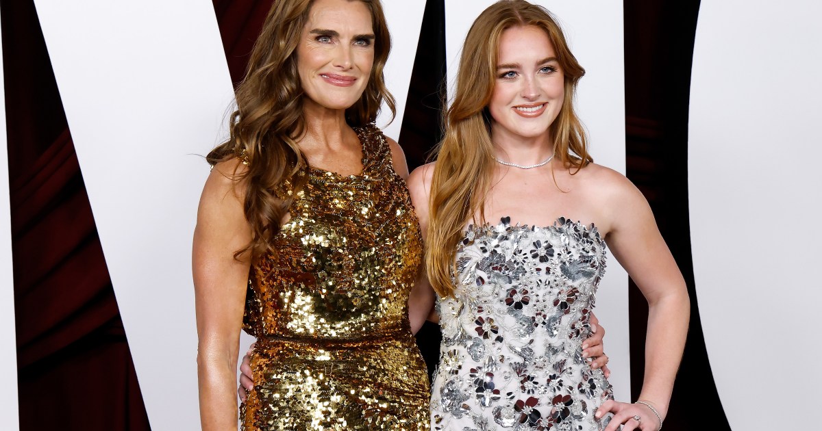 Brooke Shields in a gold dress posing with Rowan Henhy in a white and silver dress at the Glamour Women of The Year event