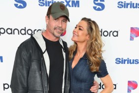 Denise Richards in a denim jumpsuit looking up at Aaron Phypers, who is wearing a leather jacket at SiriusXM